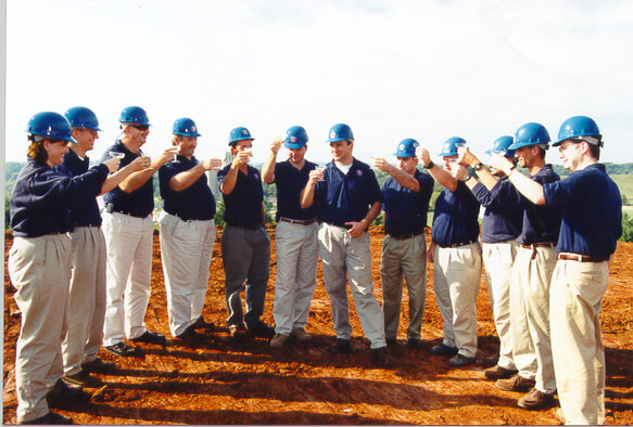 a group of men in blue contractor's hats cheering