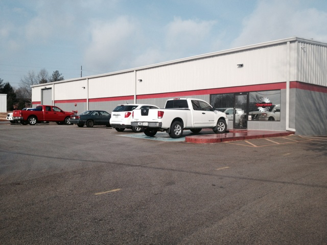 white, red and gray one store building with cars parked in front of it