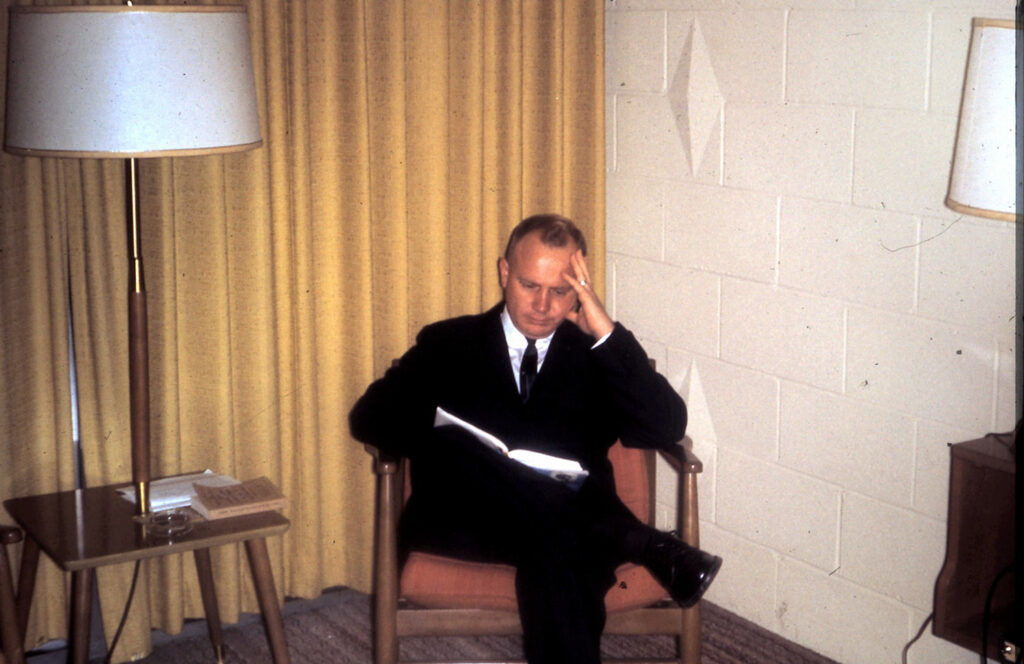 a man in black suite sitting in the chair