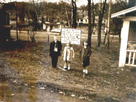 three kids are posing on the lawn